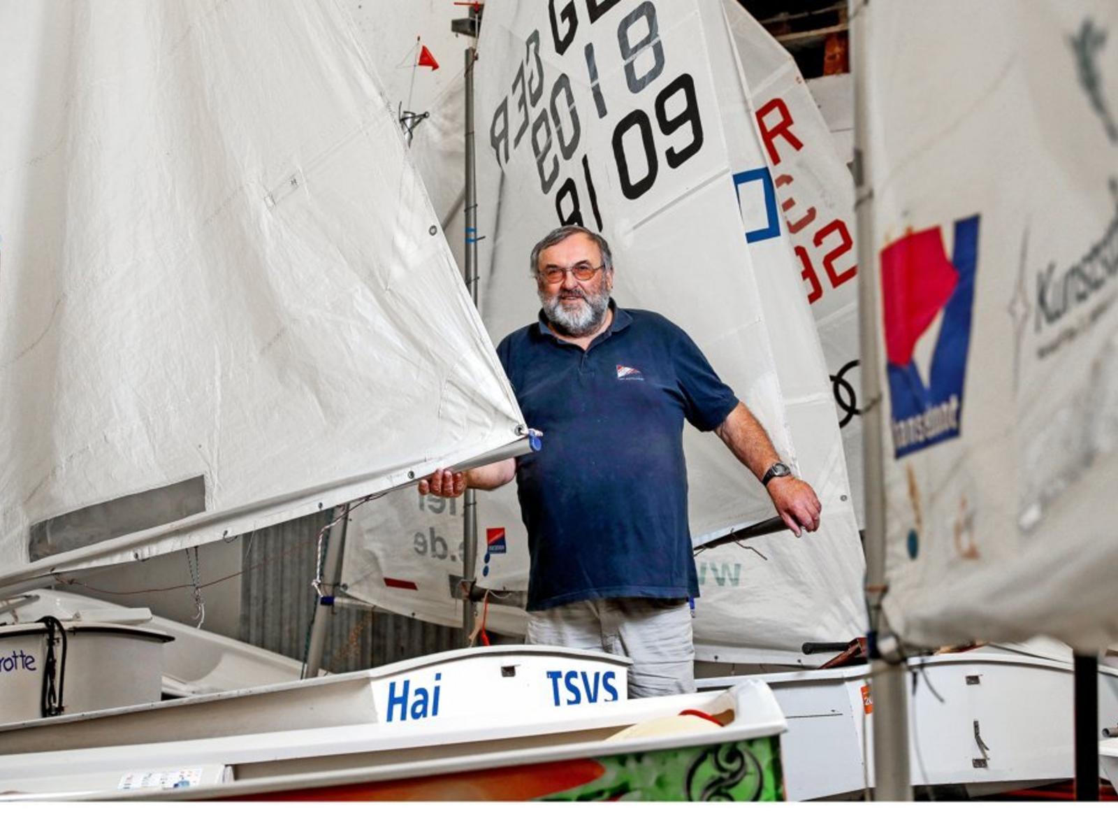 Norbert Petrausch zwischen den Optimisten-Jollen in der Bootshalle des TSV Schilksee. Quelle: Uwe Paesler